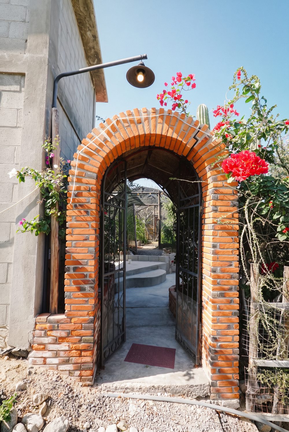 The brick entry gate with bougainvillea